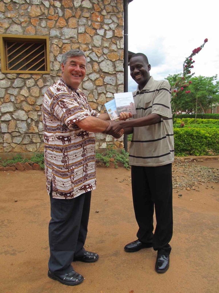 Fr. Mario Pacifici receiving the books from Geoffrey Mdala