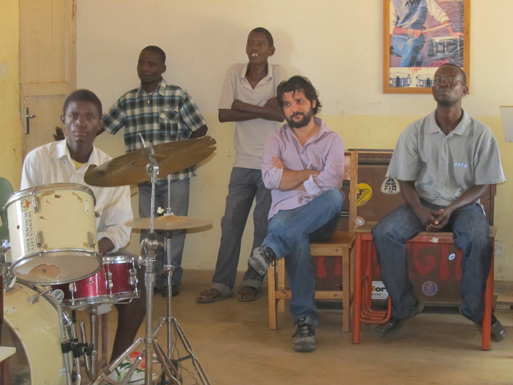 Alessandro and Thom Damba (Right) watch while Andiamo music school students perform during their training