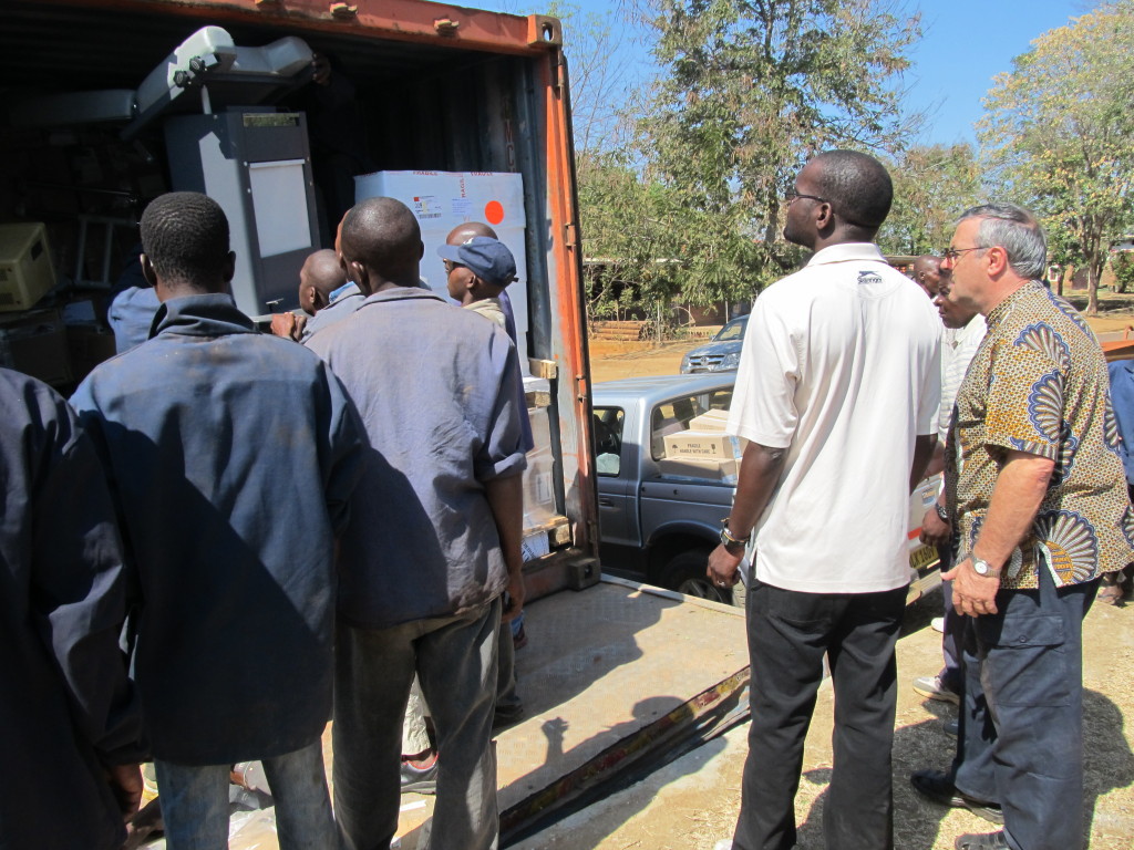 Mr. P. Bwanali and Fr. Mario watch while offloading